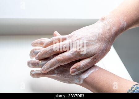 Lavage total des mains : femme se lavant les mains pour éviter des maladies comme le coronavirus Banque D'Images