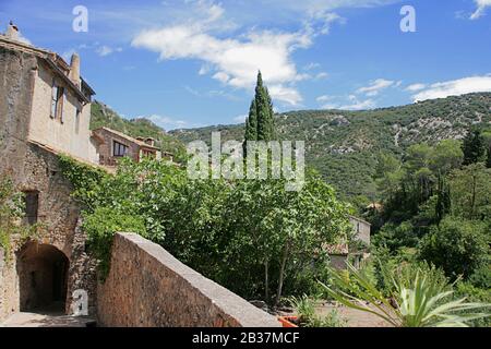 Allée tranquille (rue Corniche de Nostra Dona) dans le village médiéval de Saint-Guilhem-le-Désert; Hérault, Occitanie, France Banque D'Images