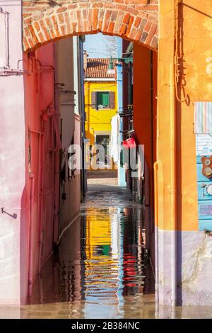 Maisons colorées sur le front de mer sur l'île de Burano pendant la haute eau (Acqua alta), Venise; Vénétie; Italie; Banque D'Images