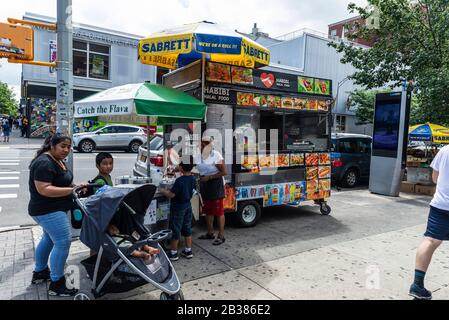 New York City, États-Unis - 3 août 2018 : camions alimentaires avec ses vendeurs et les gens autour d'une rue à Harlem, Manhattan, New York City, États-Unis Banque D'Images