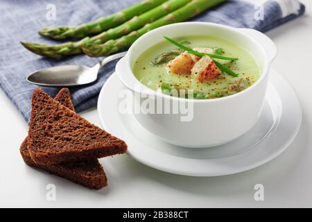 Soupe aux asperges avec du pain noir en blanc bol libre. La photographie alimentaire Banque D'Images