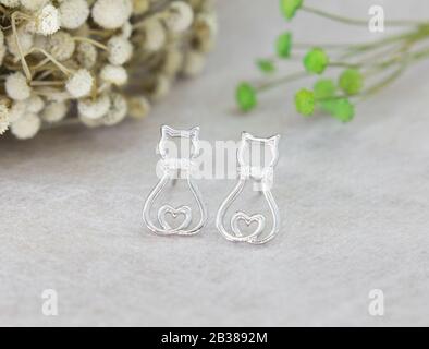 Une paire de superbes boucles d'oreilles en argent 925 en forme de chat décorées de diamant sur fond gris Banque D'Images