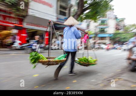 Motion photo floue de la femme vietnamienne locale vendant des légumes des paniers dans les rues de Hanoi, Vietnam, Asie du Sud-est Banque D'Images