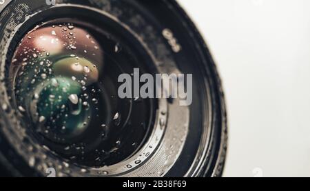Gros plan sur un magnifique objectif d'appareil photo d'eau de goutte, sur un fond blanc pour le design. Banque D'Images