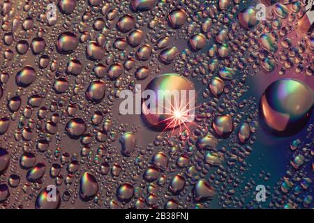 Belle goutte d'eau colorée abstraite de l'effet holographique. Motif d'arrière-plan pour la conception. Vue macro-photographie. Banque D'Images