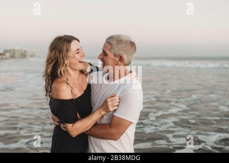 Vue latérale d'un couple marié regardant l'un l'autre dans l'océan Banque D'Images