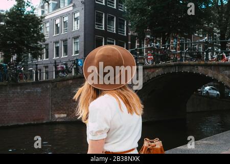 femme assise sur le canal en ville Banque D'Images