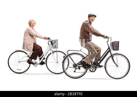 Photo pleine longueur d'un homme senior et d'une femme senior qui fait du vélo et souriant à l'appareil photo isolé sur fond blanc Banque D'Images