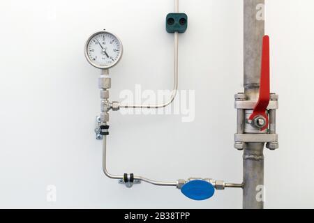tuyaux de gaz en acier avec vannes et manomètre haute pression activés le mur Banque D'Images