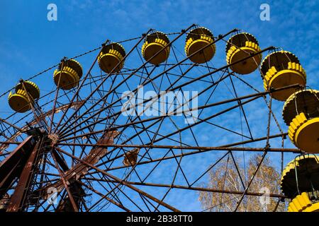La célèbre roue ferris jaune du parc d'attractions abandonné de Pripyat, Ukraine, zone d'exclusion de Tchernobyl. Banque D'Images