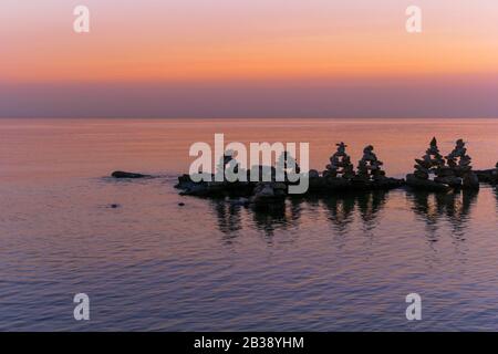 Coucher de soleil de mer rose reposant avec des pierres. Banque D'Images