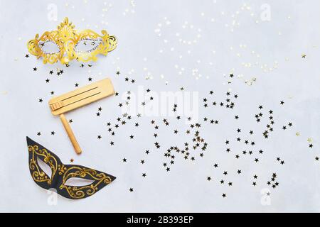 Masque de carnaval et grille en bois sur fond de béton clair. Plat du concept de célébration du Carnaval de Purim. Banque D'Images