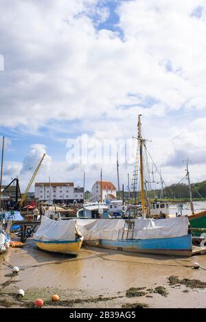 La marée basse laisse de petits bateaux toronnés dans le port de Woodbridge sur la rivière Deben dans le Suffolk Angleterre Royaume-Uni Banque D'Images