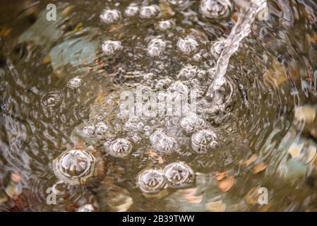 Bulles à la surface de l'eau faite par un filet d'eau Banque D'Images