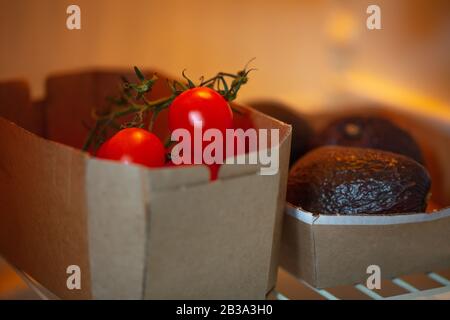 eco carton boîte de tomates pizzutello et avocats hass au réfrigérateur Banque D'Images