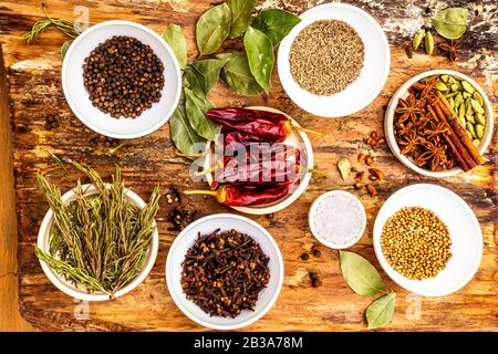 Ensemble d'épices et d'herbes différentes - poivre noir, épice, romarin, cumin, poivre chaud, feuille de laurier, coriandre, cardamome, anis étoilé, bâtons de cannelle, s Banque D'Images