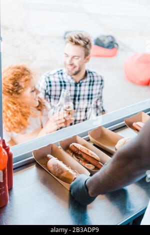 vue réduite du chef africain américain près des hot-dogs et des clients Banque D'Images