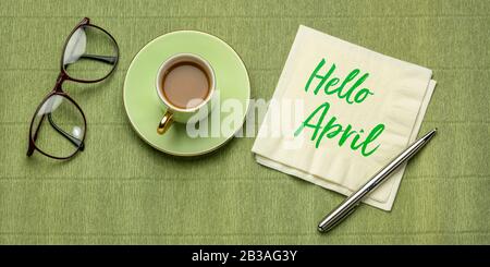 Bonjour avril - écriture sur une serviette, un bureau plat avec une tasse de café et des lunettes de lecture Banque D'Images