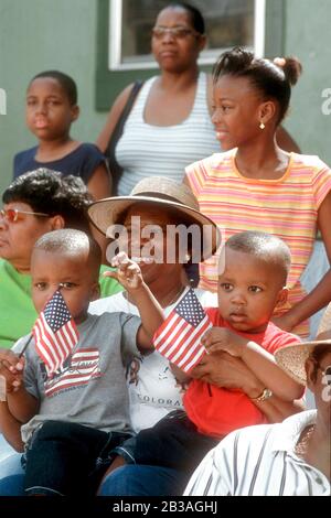 Austin, Texas USA, 19 juin 2002:: Une femme noire portant un chapeau tient deux petits garçons qui agite des drapeaux américains pendant qu'ils regardent la dix-septième parade annuelle d'Austin à travers les rues de l'est noir historique d'Austin.© Bob Daemmrich Banque D'Images