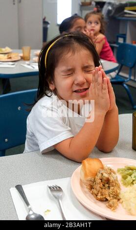 San Benito, Texas, États-Unis, 2 octobre 2002 : un enfant de famille à faible revenu dit grâce avant de manger son déjeuner à l'installation de la Gallina Head Start au nord de Brownsville.Des milliers de familles sont servies dans les comtés de Cameron et de Willacy, avec 38 écoles pour les enfants de trois et quatre ans dans le cadre du programme Head Start créé par le président Lyndon Johnson dans les années 1960.©Bob Daemmrich Banque D'Images