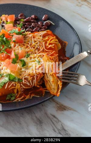 Authentique chimichanga burrito mexicain avec riz à la crème aigre et haricots noirs Banque D'Images