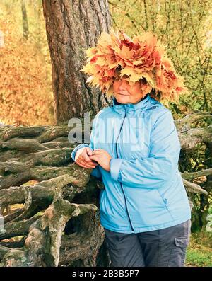 Une femme avec une couronne de feuilles d'érable jaunes sur sa tête Banque D'Images