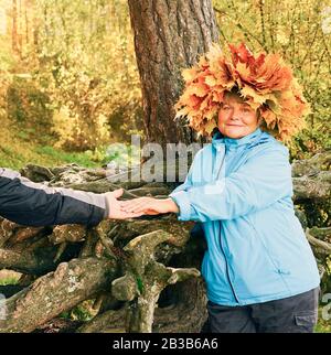 Une femme avec une couronne de feuilles d'érable jaunes sur sa tête Banque D'Images