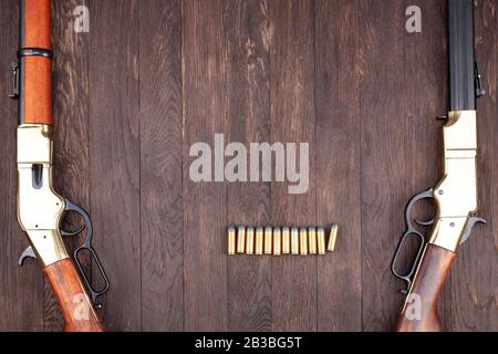 Canons ouest sauvages - fusils à levier répétant avec munitions sur table en bois Banque D'Images