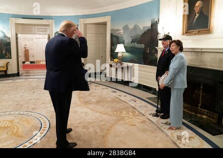 Le président américain Donald Trump salue la deuxième Guerre mondiale, vétéran de la bataille d'Iwo Jima, Ira Rigger, 97 ans, et sa femme, Yong Rigger, dans la salle d'accueil diplomatique de la Maison Blanche le 3 mars 2020 à Washington, DC. Banque D'Images