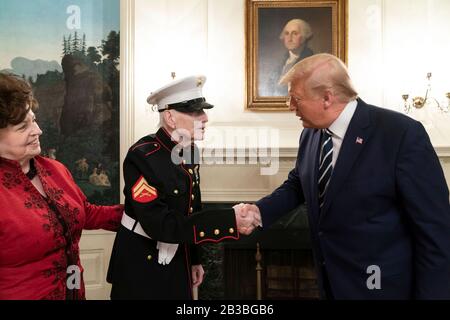 Le président américain Donald Trump salue la deuxième Guerre mondiale, vétéran de la Marine de la bataille d'Iwo Jima, John J. Sheridan, 95 ans, et sa fille Dianne Fairbaugh dans la salle d'accueil diplomatique de la Maison Blanche le 3 mars 2020 à Washington, DC. Banque D'Images