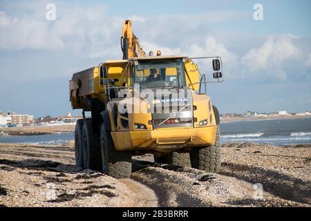 Hayling Island, Hampshire. Des machines de terrassement sont utilisées chaque année pour déplacer du gravier de plage de l'Ouest vers l'est afin de contrecarrer l'effet de la dérive des côtes Banque D'Images