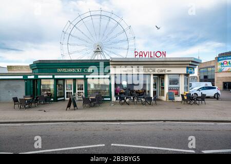 Vue frontale sur le Pavillion Cafe et le café Inversnecky, le Ferris Wheel of Codonas Amusement Park en arrière-plan, Seagull Flying, Aberdeen Banque D'Images