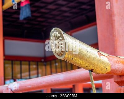 Détail architectural du bâtiment japonais avec joint impérial chrysanthème plaqué or sur fond orange. Banque D'Images