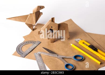 dinosaure origami et koala en papier. papier, règle, crayons, couteau. passe-temps intéressant Banque D'Images