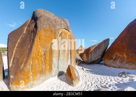 D'énormes roches orange dans le sable près de l'océan. Plage De Squeaky, Parc National De Wilsons Promontory, Australie Banque D'Images