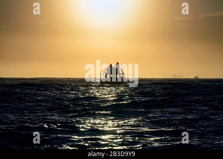 Silhouette de bateau à vitesse dans l'océan au lever du soleil. Afrique Du Sud Banque D'Images