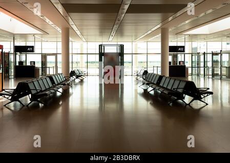 Vide portes de départ de l'aéroport international terminal vol salon d'attente. Des rangées de sièges vides dans une salle d'attente avec portes de départ de vol dessées. Air t Banque D'Images