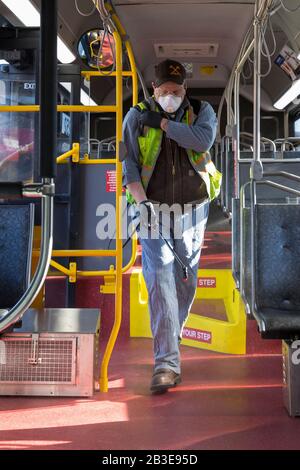 Larry Bowles, un employé de maintenance de King County Metro, applique un désinfectant avec un pulvérisateur de produits chimiques dans un autocar à la base de l'Atlantique du comté de King à Seattle le 4 mars 2020. Plus tôt dans la semaine, l'agence avait augmenté la fréquence de nettoyage de sa flotte de 1 600 autobus à une procédure quotidienne en réponse à de nouveaux coronavirus. King County Metro a maintenant mis en œuvre la méthode d'utilisation du désinfectant Virex II 256 avec un pulvérisateur de produits chimiques pour aider à protéger les passagers. Banque D'Images