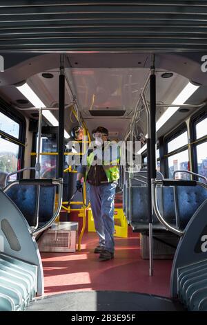 Larry Bowles, un employé de maintenance de King County Metro, applique un désinfectant avec un pulvérisateur de produits chimiques dans un autocar à la base de l'Atlantique du comté de King à Seattle le 4 mars 2020. Plus tôt dans la semaine, l'agence avait augmenté la fréquence de nettoyage de sa flotte de 1 600 autobus à une procédure quotidienne en réponse à de nouveaux coronavirus. King County Metro a maintenant mis en œuvre la méthode d'utilisation du désinfectant Virex II 256 avec un pulvérisateur de produits chimiques pour aider à protéger les passagers. Banque D'Images