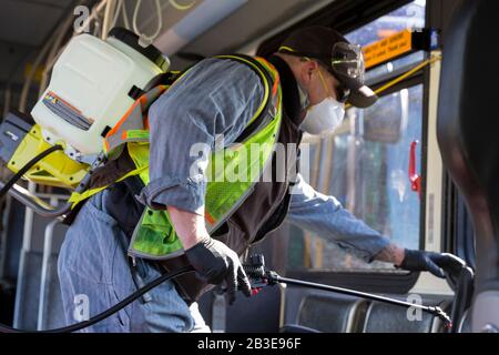 Larry Bowles, un employé de maintenance de King County Metro, applique un désinfectant avec un pulvérisateur de produits chimiques dans un autocar à la base de l'Atlantique du comté de King à Seattle le 4 mars 2020. Plus tôt dans la semaine, l'agence avait augmenté la fréquence de nettoyage de sa flotte de 1 600 autobus à une procédure quotidienne en réponse à de nouveaux coronavirus. King County Metro a maintenant mis en œuvre la méthode d'utilisation du désinfectant Virex II 256 avec un pulvérisateur de produits chimiques pour aider à protéger les passagers. Banque D'Images