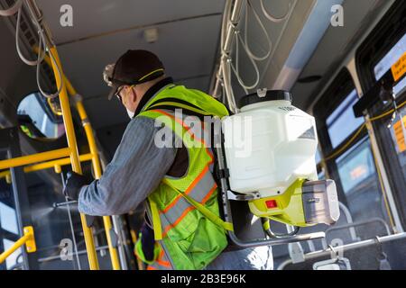 Larry Bowles, un employé de maintenance de King County Metro, applique un désinfectant avec un pulvérisateur de produits chimiques dans un autocar à la base de l'Atlantique du comté de King à Seattle le 4 mars 2020. Plus tôt dans la semaine, l'agence avait augmenté la fréquence de nettoyage de sa flotte de 1 600 autobus à une procédure quotidienne en réponse à de nouveaux coronavirus. King County Metro a maintenant mis en œuvre la méthode d'utilisation du désinfectant Virex II 256 avec un pulvérisateur de produits chimiques pour aider à protéger les passagers. Banque D'Images