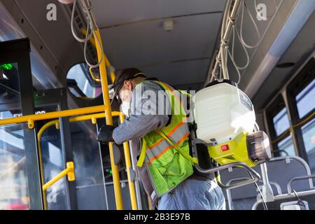 Larry Bowles, un employé de maintenance de King County Metro, applique un désinfectant avec un pulvérisateur de produits chimiques dans un autocar à la base de l'Atlantique du comté de King à Seattle le 4 mars 2020. Plus tôt dans la semaine, l'agence avait augmenté la fréquence de nettoyage de sa flotte de 1 600 autobus à une procédure quotidienne en réponse à de nouveaux coronavirus. King County Metro a maintenant mis en œuvre la méthode d'utilisation du désinfectant Virex II 256 avec un pulvérisateur de produits chimiques pour aider à protéger les passagers. Banque D'Images