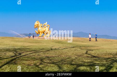 Chiang Rai, Thaïlande - 21 février 2017 : spectaculaire ombre d'arbres incurvées et statue du Lion d'or au parc Singha à Chiang Rai, Thaïlande Banque D'Images