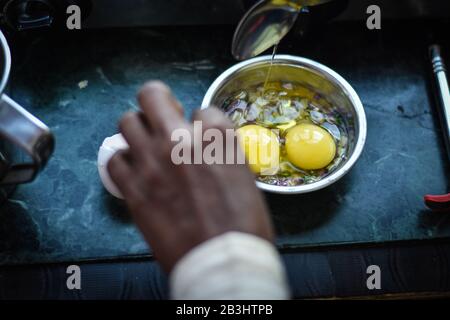 homme mélangeant un oeuf dans un bol pour la recette d'omelette Banque D'Images