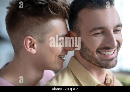 Gros plan sur un couple gay souriant avec plaisir Banque D'Images