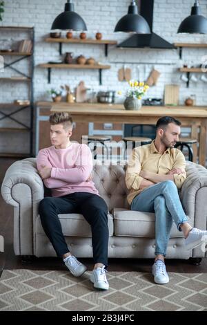 Deux hommes assis sur le canapé ne se looking pas l'un à l'autre Banque D'Images