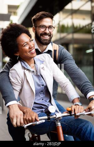 Des gens joyeux qui vont faire un tour à vélo. Un couple heureux s'amuser en ville. Banque D'Images