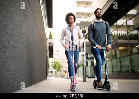 Un jeune couple heureux à profiter ensemble tout en faisant du scooter électrique sur la rue de la ville