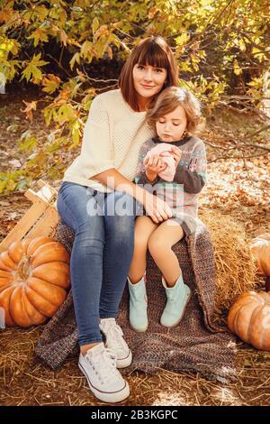 Maman et ses filles sont détenues par un petit hérisson. Peinture d'automne tactile, feuilles d'automne jaunes en arrière-plan Banque D'Images