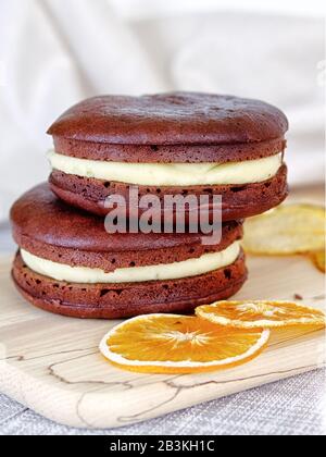 Dessert - sandwich Cheesecake au chocolat avec remplissage d'orange au lait. Décoration avec fruits. Vue verticale. Banque D'Images